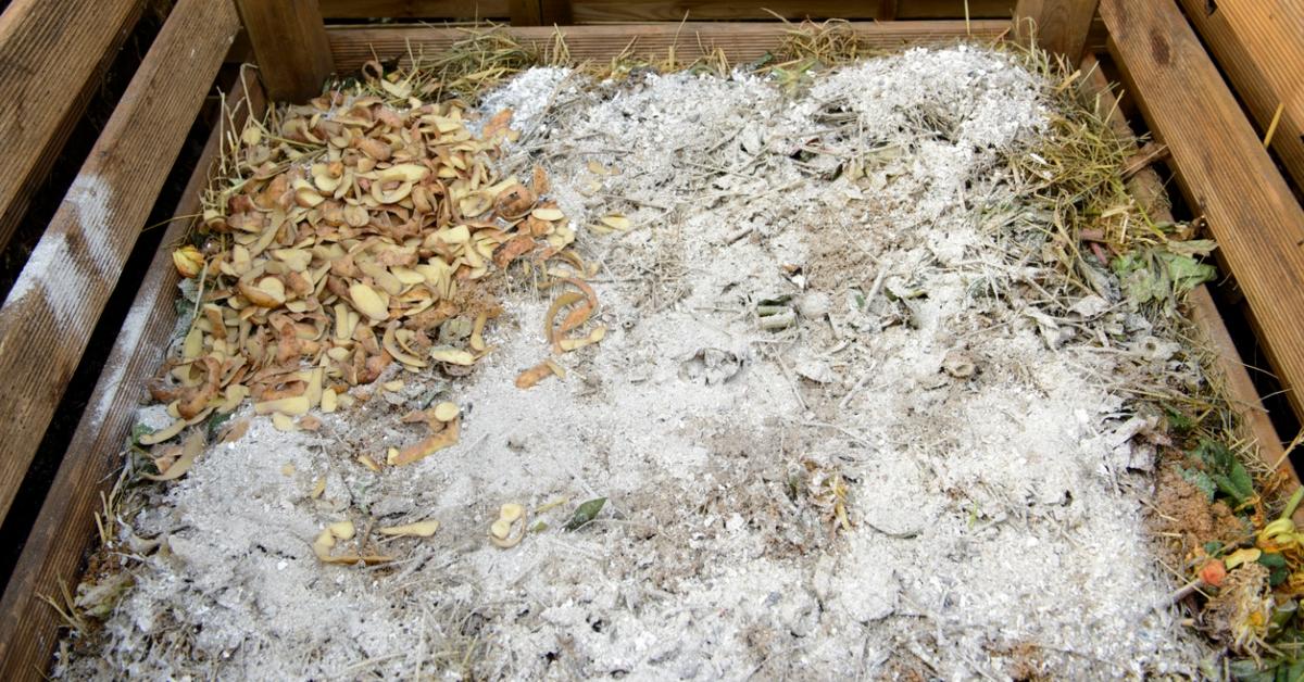Ash scattered inside a compost enclosure.