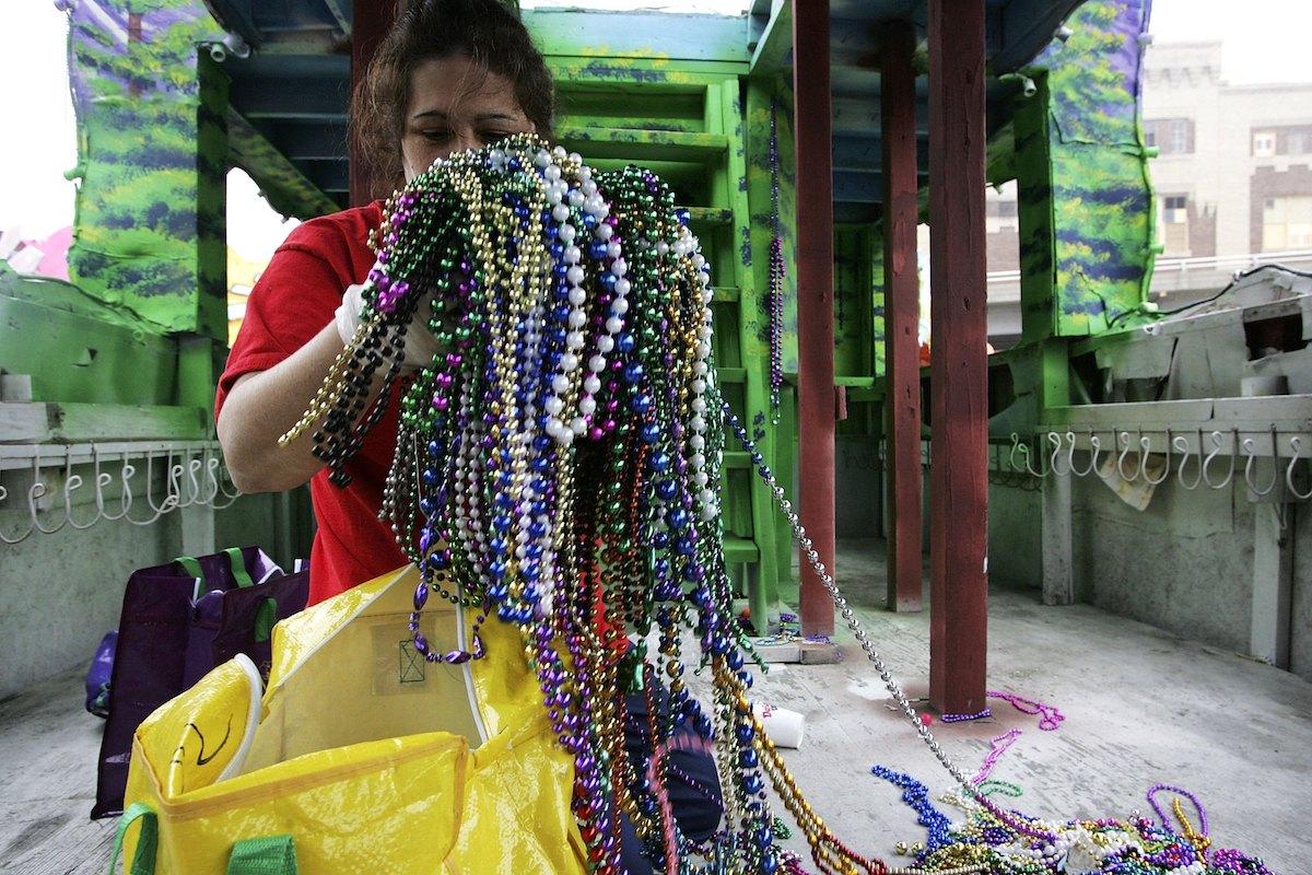 Person holds pile of Mardi Gras throws