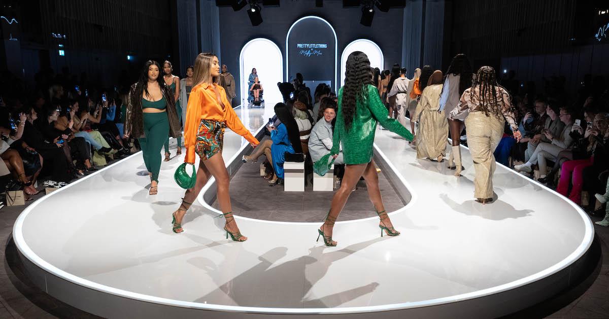 Models walk on a runway at the PrettyLittleThing fashion show