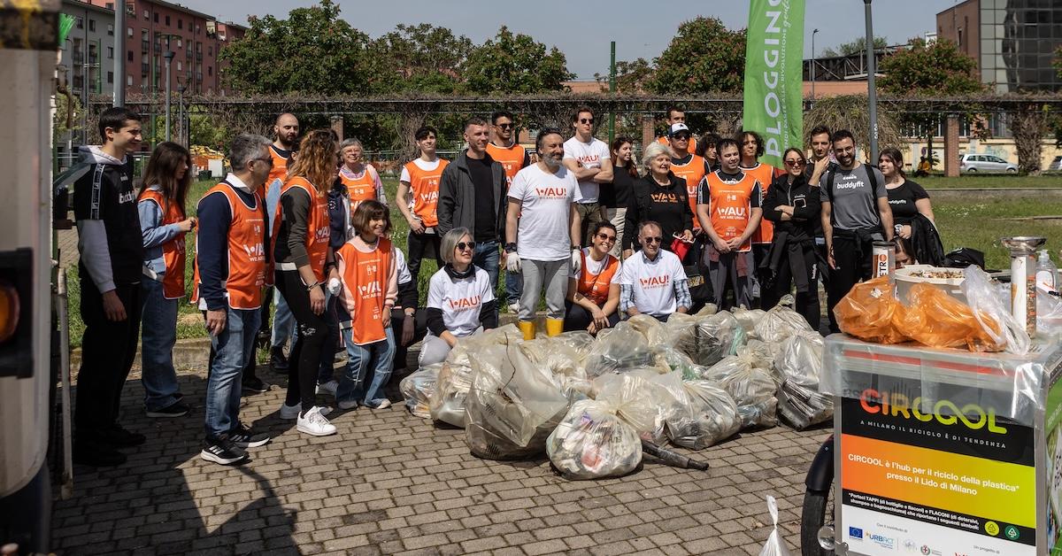 Group of about 30 volunteers stand near bags of collected trash in a clean up event held by association WAU! (We Are Urban) to clean the streets and the public spaces of Certosa district on the occasion of Earth Day on April 22, 2023 in Milan, Italy.