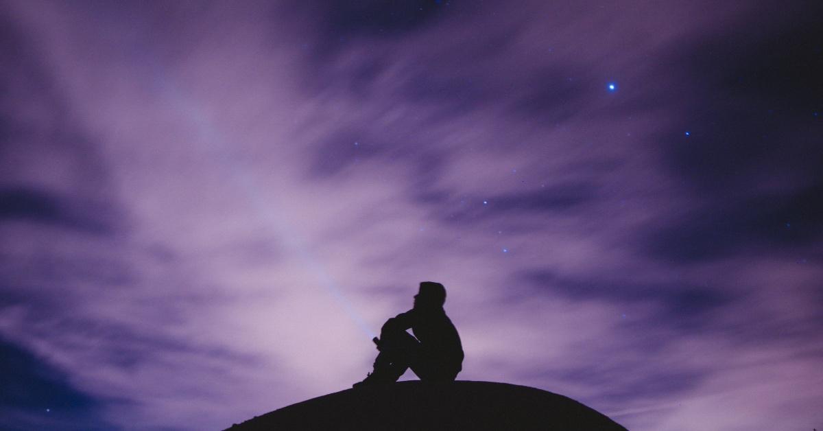 A person looking up at the stars at night.