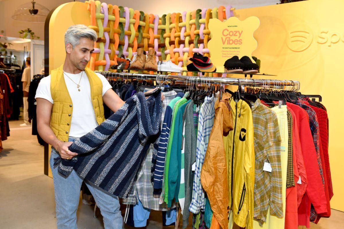Tan France browses a rack at a thrift store